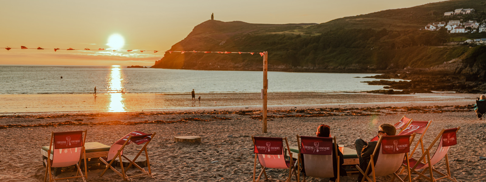 People enjoying drinks at Foraging Vintners as the sun sets in Port Erin