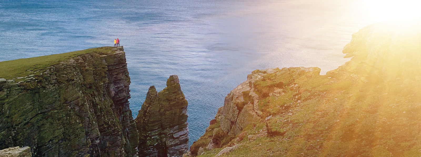 Two walkers on a section of the Raad ny Foillan overlooking Sugarloag Rock and the Chasms