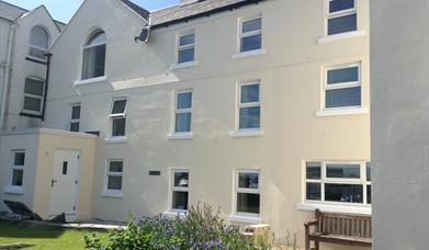 Photo of Laxey Beach Apartment situated on the second floor of cream rendered property