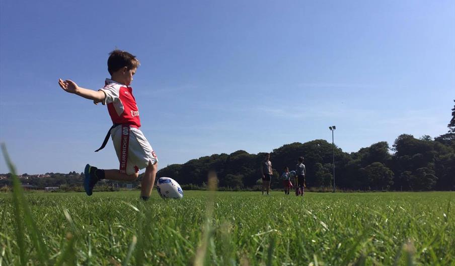 Child kicking a rugby ball