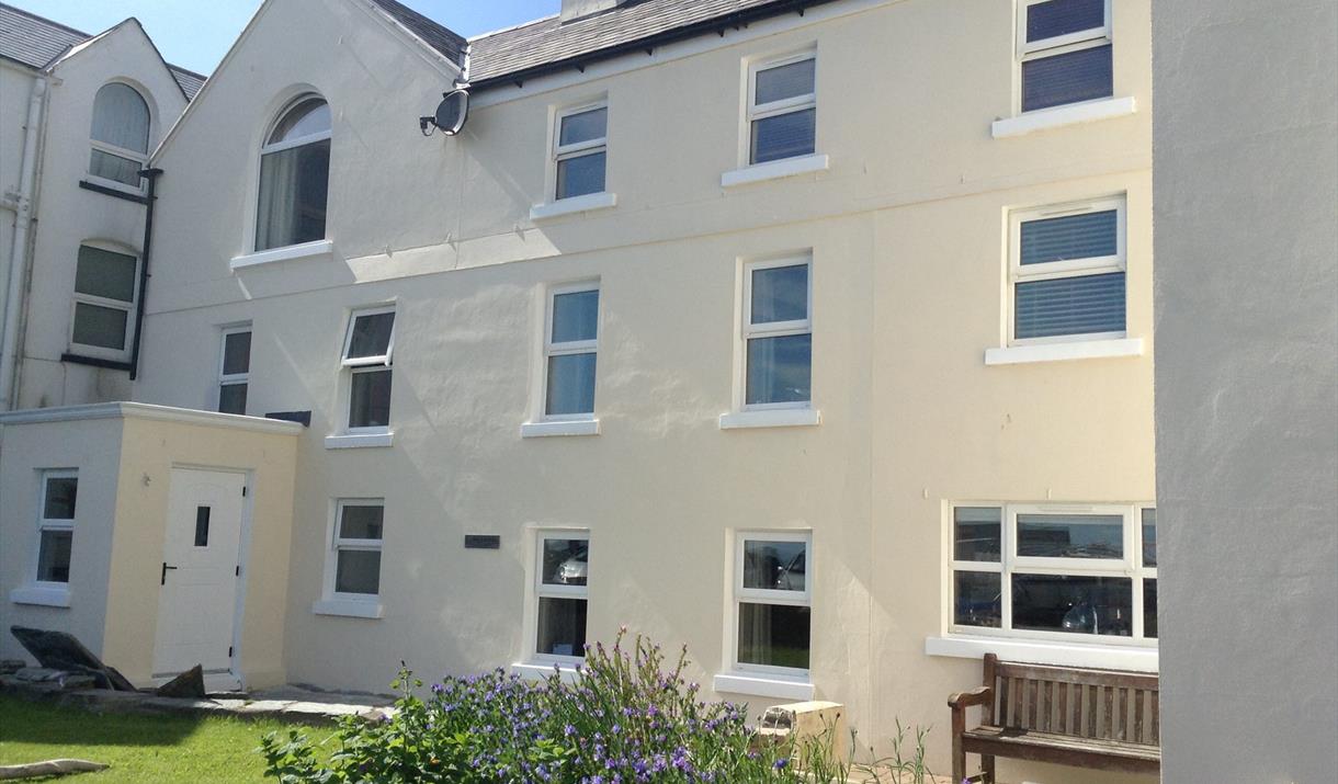 Photo of Laxey Beach Apartment situated on the second floor of cream rendered property