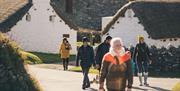 A group of visitors walking through the village at the traditional Hop tu Naa event