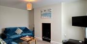 Downstairs lounge at Bay View Cottage with sea view and coal effect electric log burner