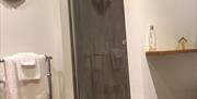 1200mm x 1200mm shower with glass door next to radiator